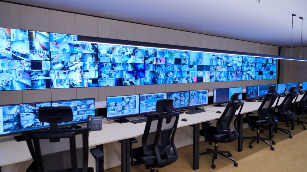 A room with several screens with CCTV footage on them.